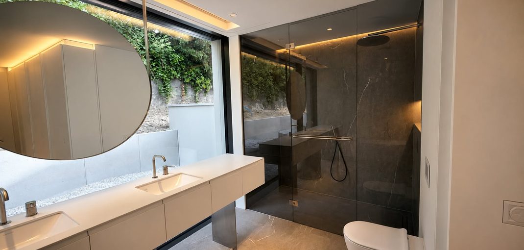 Walk-in-Dusche mit getöntem Glas in Graphit vor dunklem Marmor, realisiert von Traumglass